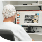 Dentista mirando la pantalla de un ordenador en una oficina